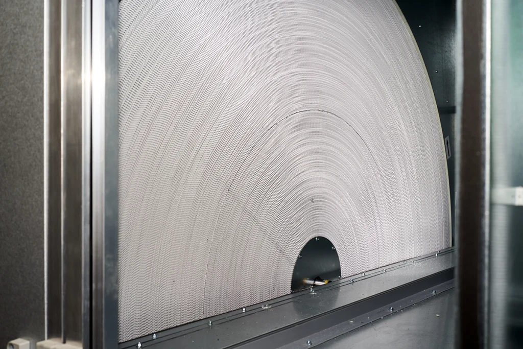 Close-up of an energy recovery wheel inside an HVAC ventilation system transferring heat and humidity for energy efficiency.