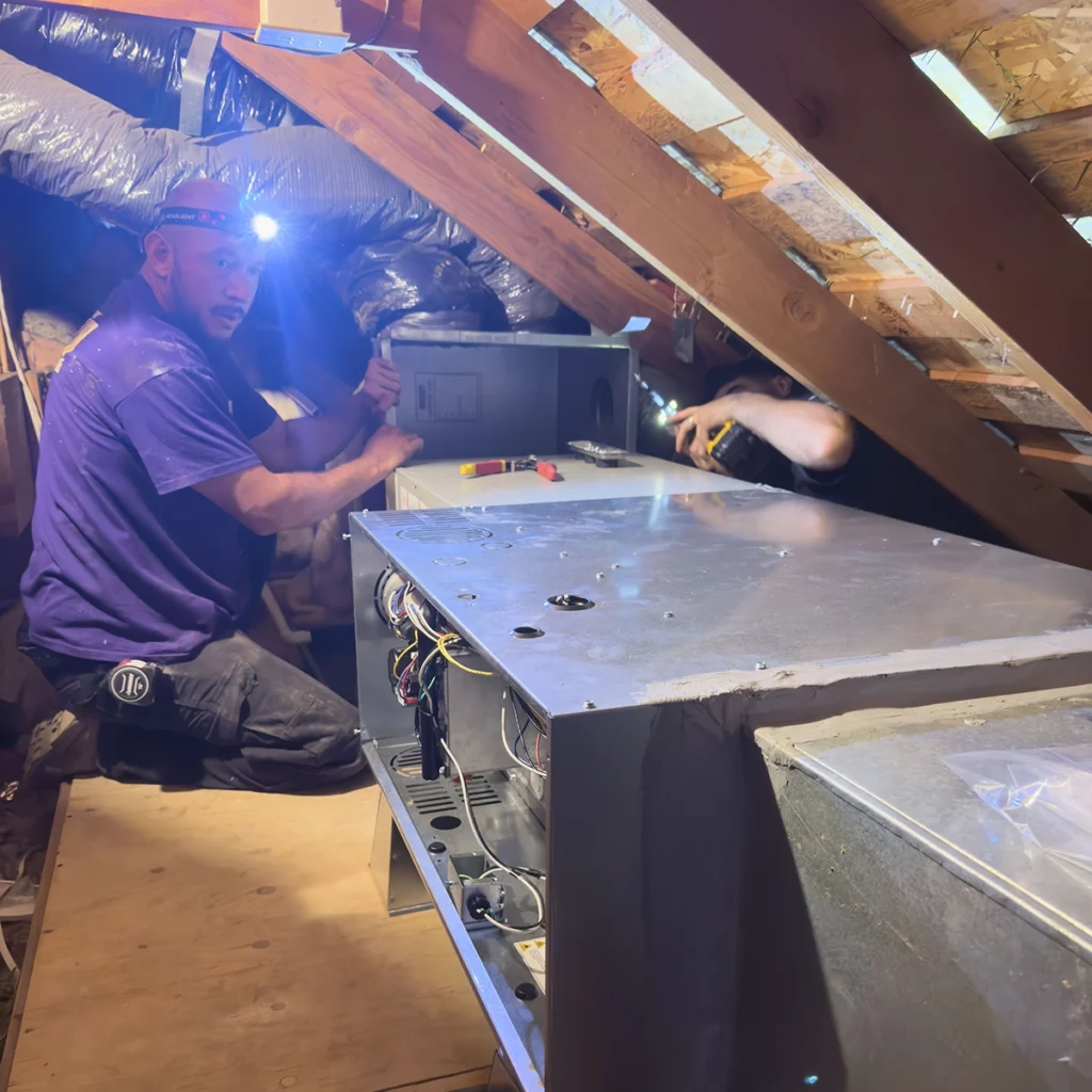 Technicians from Rocket Air Heating & Cooling performing furnace repair in a Manteca attic